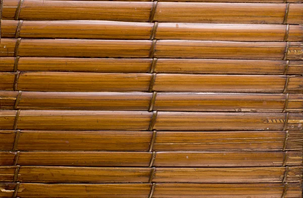 Bamboo sticks brown wooden background with thread uniting.
