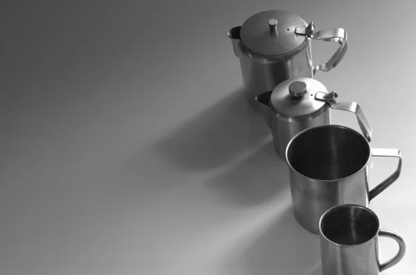 Stainless steel flip lid teapots and tea cups.