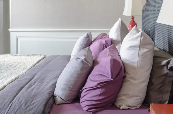 Row of pillows on bed in classic bedroom