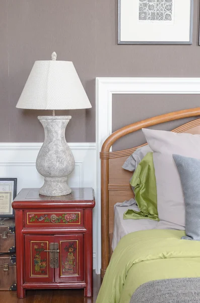 Chinese lamp style on red table side in classic bedroom