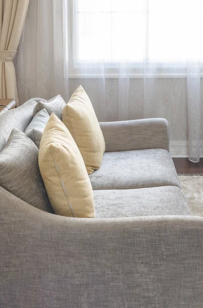 Yellow pillow on modern grey sofa in living room