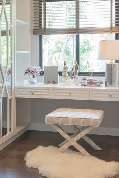 White dressing table and chair with women's accesories