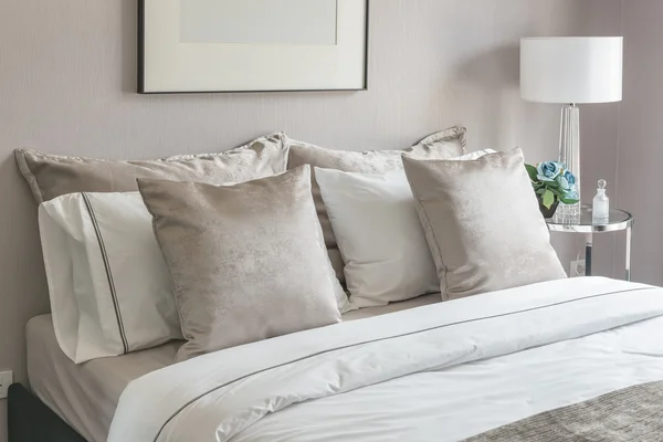 Classic bedroom style with set of pillows on bed and white lamp