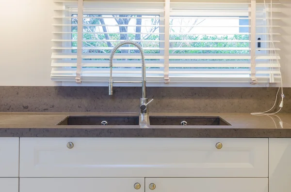 Water tap and sink in kitchen at home
