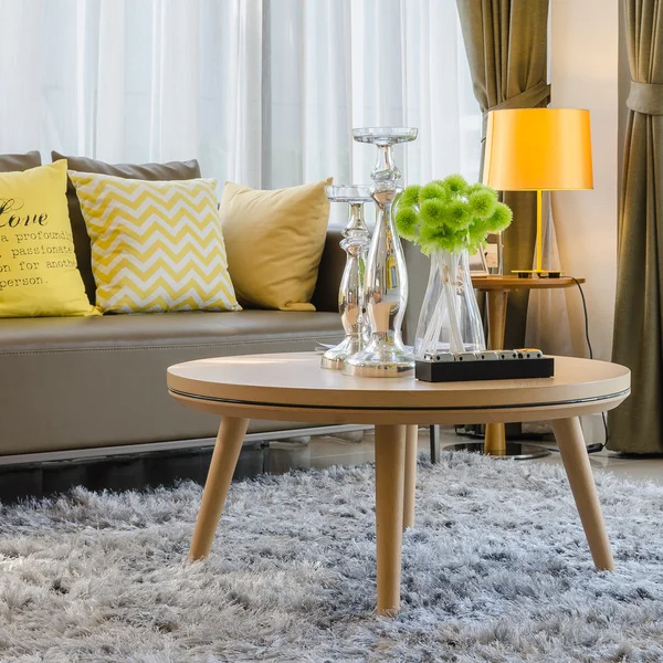 Wooden round table on carpet in living room