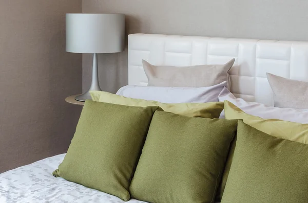 Modern bedroom with green pillows