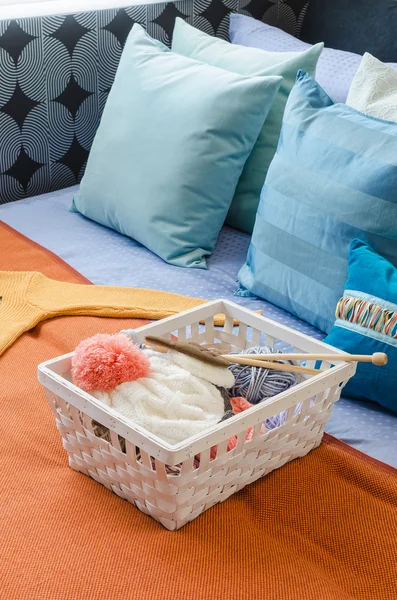Basket of crochet on colorful bed in bedroom