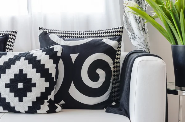 Black and white pattern pillows on white sofa