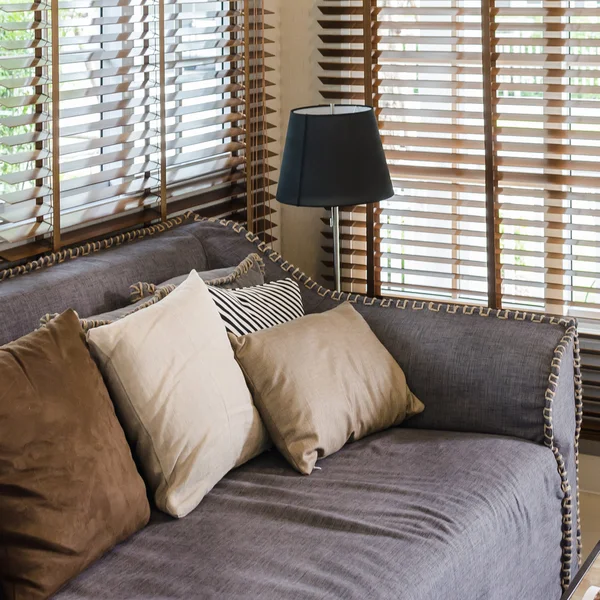 Living room design with pillows on sofa and bamboo blind