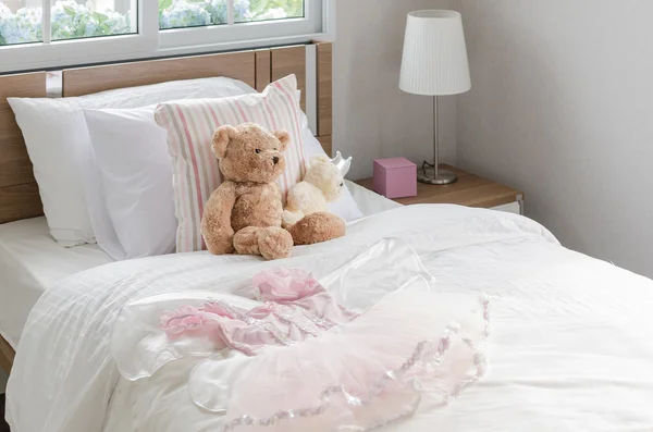 White bedroom with pillows and doll