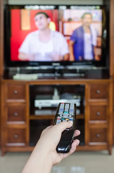 Hand holding TV remote control