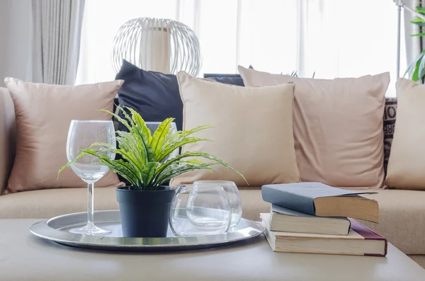 Plant in black vase with glass on plate in living room