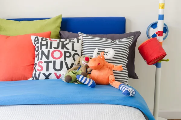 Kid\'s bedroom with colorful pillows and dolls