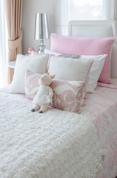 Kid\'s bedroom with doll on bed in pink color style