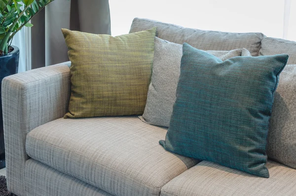 Pillows on blue sofa with lamp