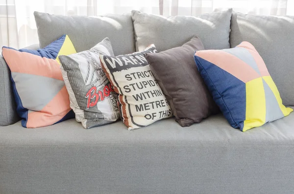 Colorful pillows on modern grey sofa in living room