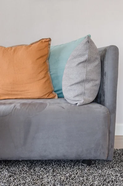 Orange color pillow on grey sofa in living room