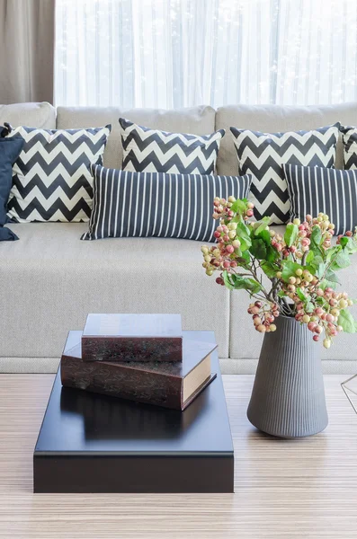 Vase of flower with books on wooden table in living room