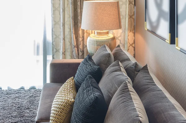 Gold and black color pillows on grey sofa