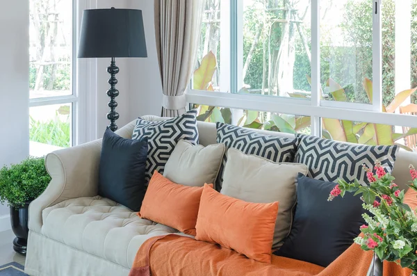 Orange pillows and blanket on classic sofa in living room