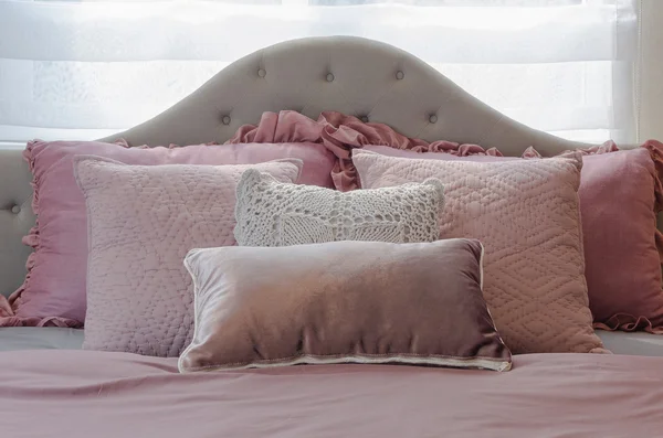 Pink pillows on classic bed in girl's bedroom