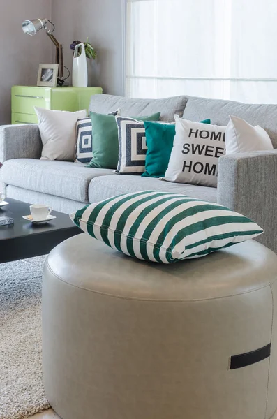 Green and white pillows on round chair