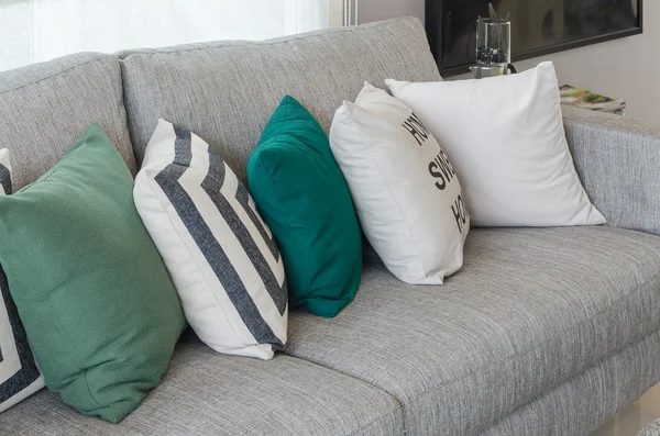 Green and white pillows on round chair