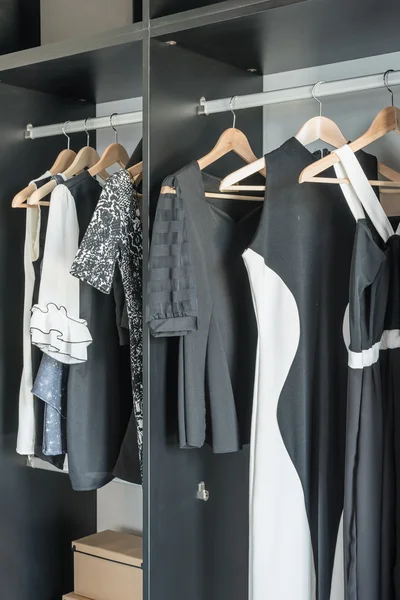 Black and white clothes hanging in closet