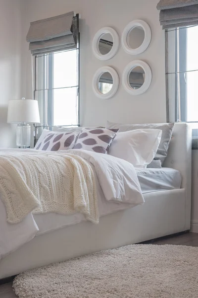 Modern white bedroom with white bed and white lamp