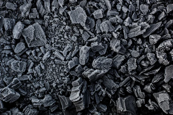 Black coal in white frost.