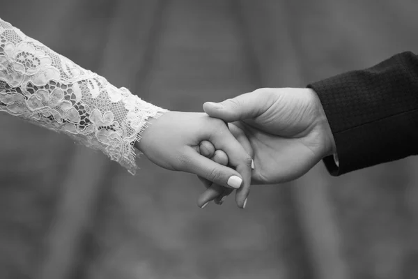Couple tenderly holding hands,black and white,close