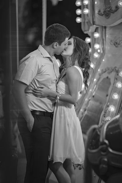 Couple kissing on the background of the French carousel, night photo,black and white