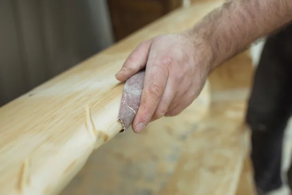 Man polishing wood with sandpaper, men's hands, wood work