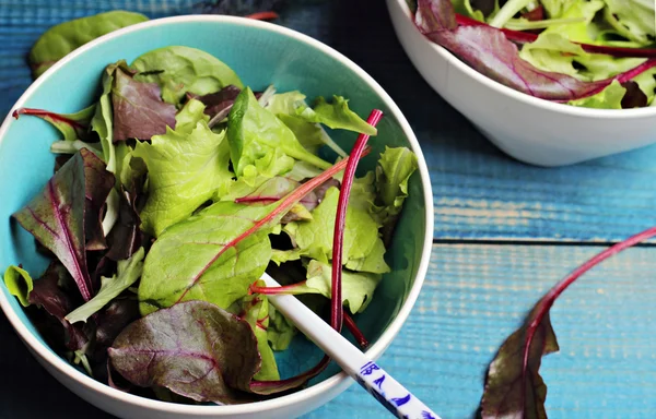 Salad in bowl on blue table. Fresh raw food diet salad.  Vegetarian food concept, healthy life style