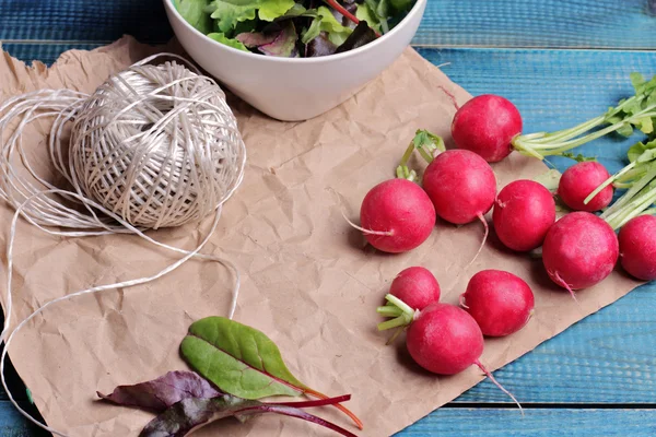 Radishes on blue rustic table. Fresh raw food diet salad.  Vegetarian food concept, healthy life style