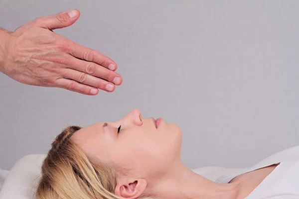 Attractive young woman having reiki healing treatment , alternative  medicine concept.