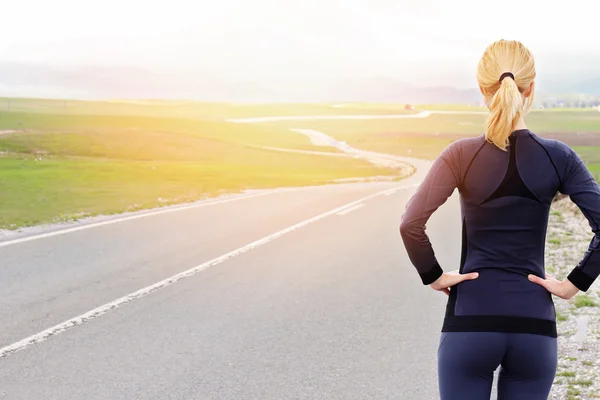 Woman athlete runner getting ready to run in beautiful nature mountain landscape.  Jogging, sport, fitness, active lifestyle concept