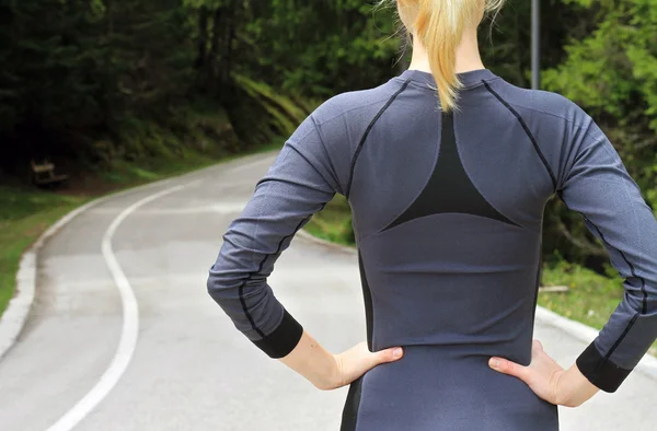 Woman athlete runner getting ready to run in beautiful nature forest landscape. Jogging, sport, fitness, active lifestyle concept