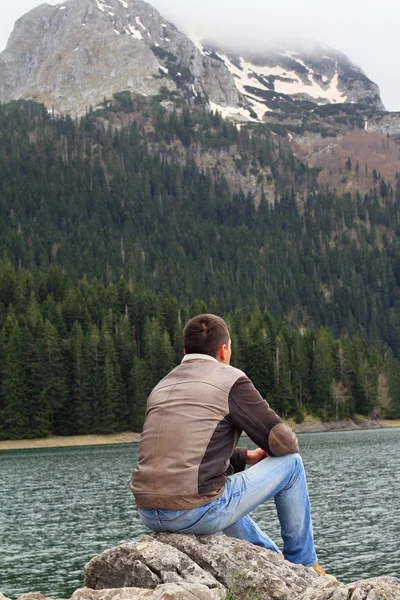 Traveler Man enjoying mountain lake view. Man looking at  horizon, loneliness concept.