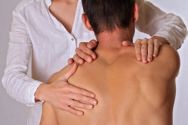 Chiropractic, osteopathy, physical therapy. Therapist  doing healing treatment on man's back. Alternative medicine, pain relief concept