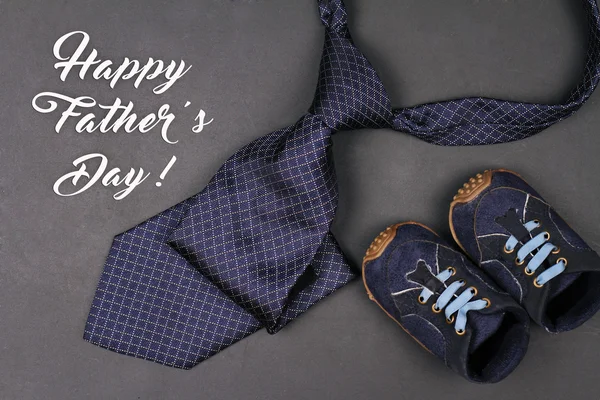 Happy father\'s day greeting card design. Father tie and and little shoes from baby boy, vintage image