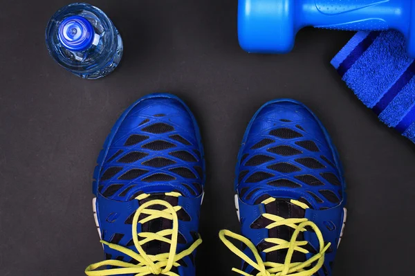 Sport, Fitness, working out concept background. Sport shoes, dumbbells and bottle of water close up. Fitness equipment flat lay composition