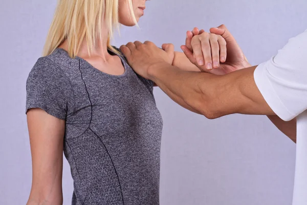 Chiropractic, osteopathy, manual therapy. Therapist doing healing treatment on woman's hand / shoulder . Alternative medicine, physiotherapy, pain relief concept