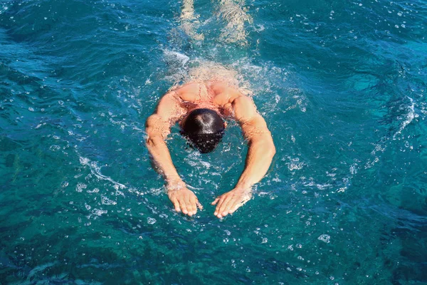 Strong athletic man swimming butterfly style in the sea. Active summer holiday vacation. Sport, healthy lifestyle concept