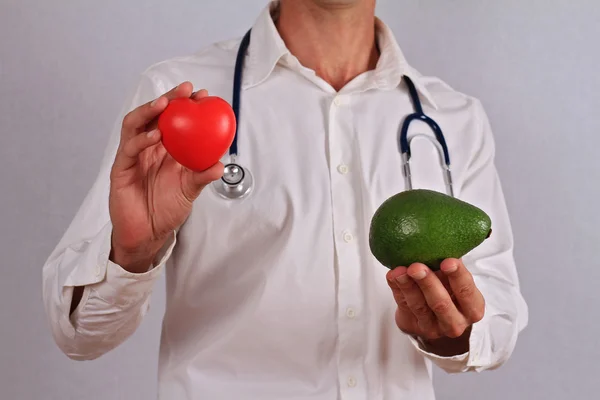 Doctor holding avocado. Good Fats and Heart Health, Hypertension prevention