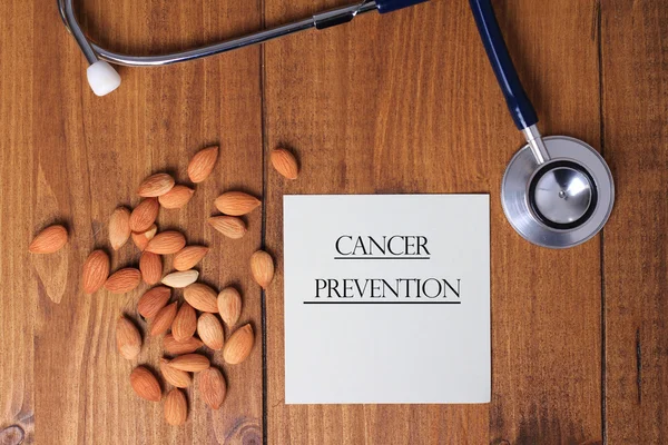 Apricot Seeds amd blank paper on wooden background, copy space. Vitamin b 17. Cancer prevention concept, alternative medicine.
