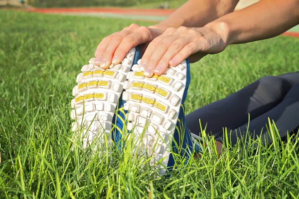 Woman stretching after workout. Closeup on female shoe and legs. Woman autumn  fitness workout. Jogging, sport, healthy active lifestyle concept.