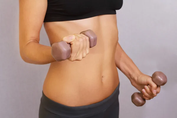 Fit, shape woman pumping up muscles with dumbbells. Close up of torso of female holding barbells. Sport, fitness ,workout concept.