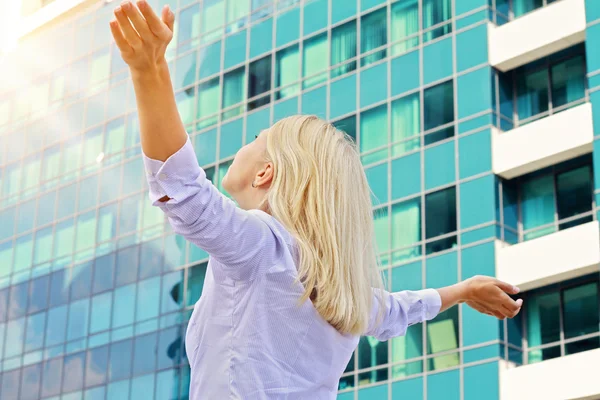 Young professional , attractive, blonde business woman raising hands celebrating success. Winner, success, freedom concept