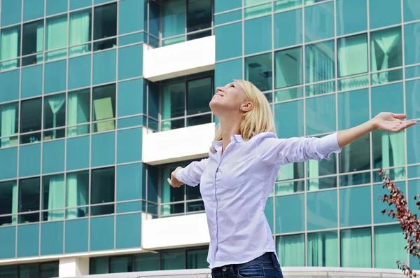 Young professional , attractive, blonde business woman raising hands celebrating success. Winner, success, freedom concept